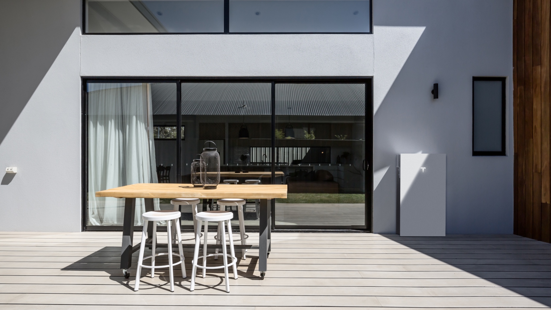 Tesla Powerwall aan de buitenmuur van een moderne woning