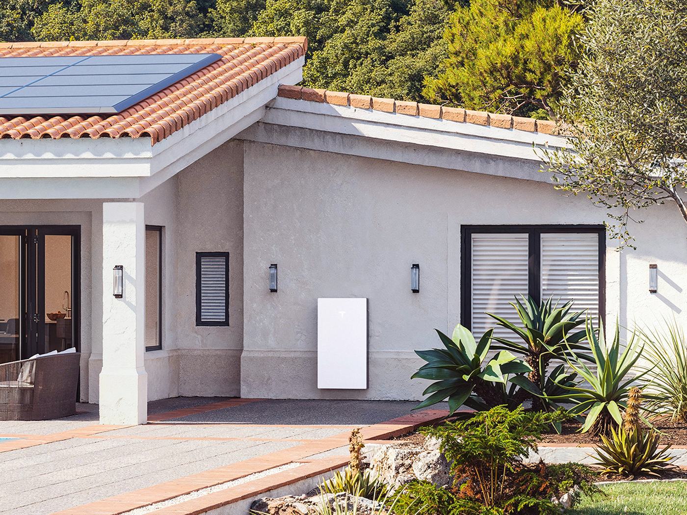 Tesla Powerwall 3 aan de gevel van een woning met bestaande zonnepanelen op het dak
